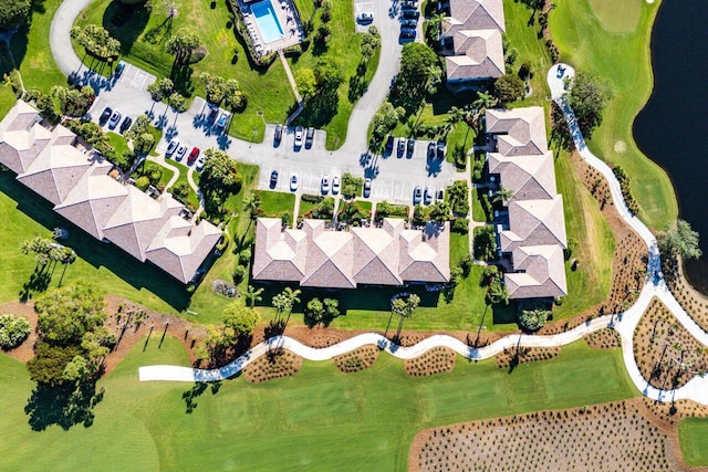 birds eye view of property with golf course view and a water view