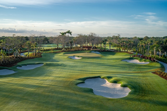 view of community with view of golf course and a lawn