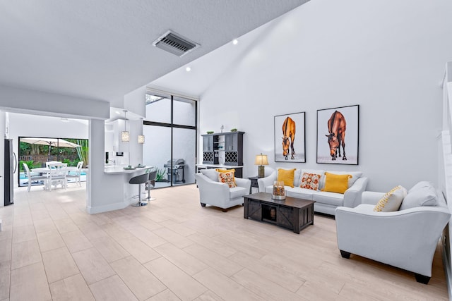 living room featuring visible vents, floor to ceiling windows, recessed lighting, light wood-style flooring, and high vaulted ceiling