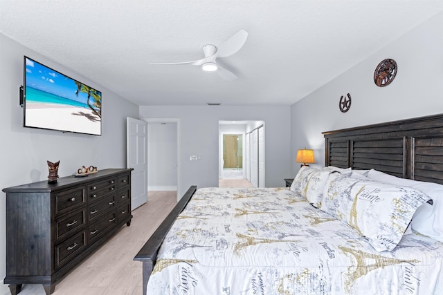 bedroom featuring light wood-style flooring, a ceiling fan, visible vents, and ensuite bathroom