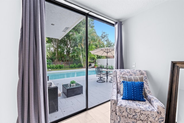 doorway with a textured ceiling and floor to ceiling windows