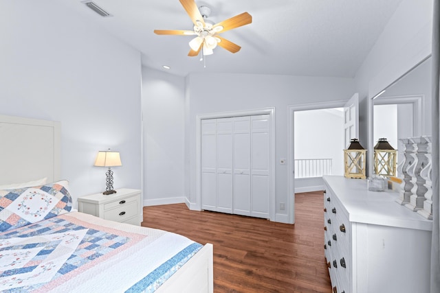 bedroom with vaulted ceiling, dark wood-style floors, visible vents, and baseboards