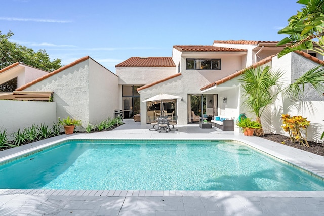 outdoor pool with a patio area and an outdoor living space