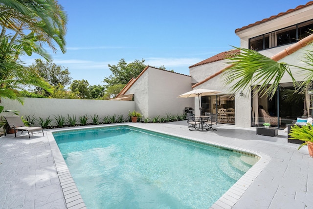 view of pool featuring a patio area, a fenced in pool, and fence