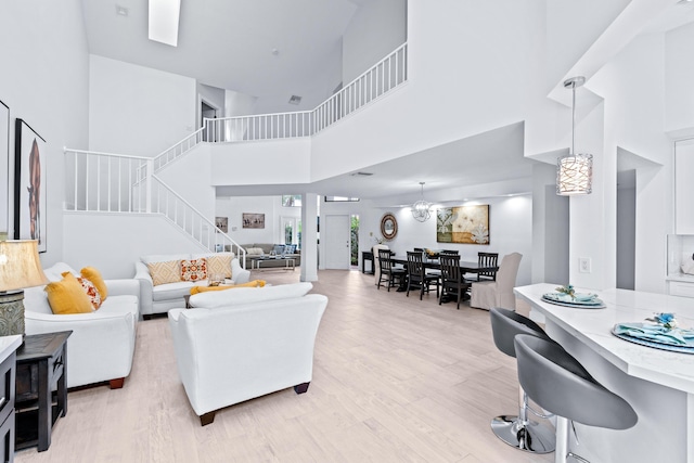 living area with light wood finished floors, stairs, and a high ceiling