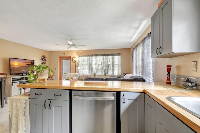 kitchen featuring wooden counters, a peninsula, ceiling fan, and stainless steel dishwasher