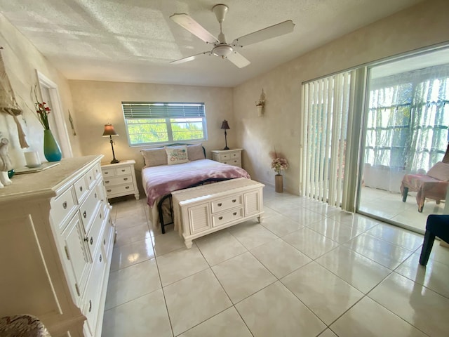 bedroom with light tile patterned floors, a ceiling fan, and a textured ceiling