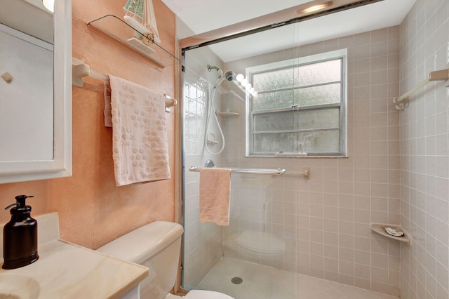 bathroom with a shower stall and toilet