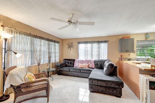 living area with light tile patterned floors, a textured ceiling, and ceiling fan