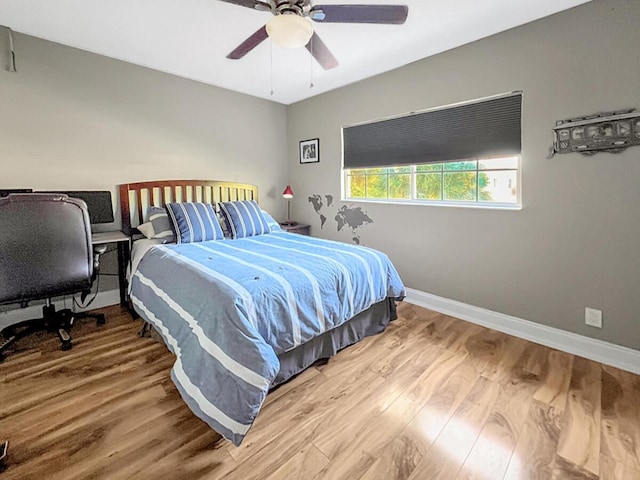 bedroom with ceiling fan, baseboards, and wood finished floors