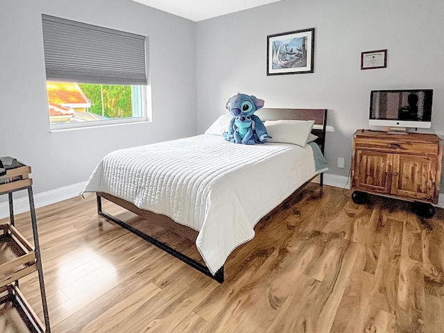 bedroom with wood finished floors and baseboards