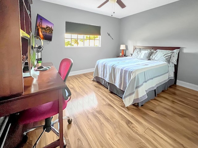 bedroom featuring ceiling fan, baseboards, and wood finished floors