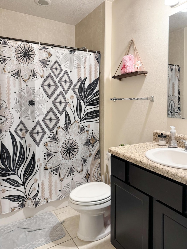 bathroom featuring toilet, a shower with curtain, tile patterned floors, a textured ceiling, and vanity