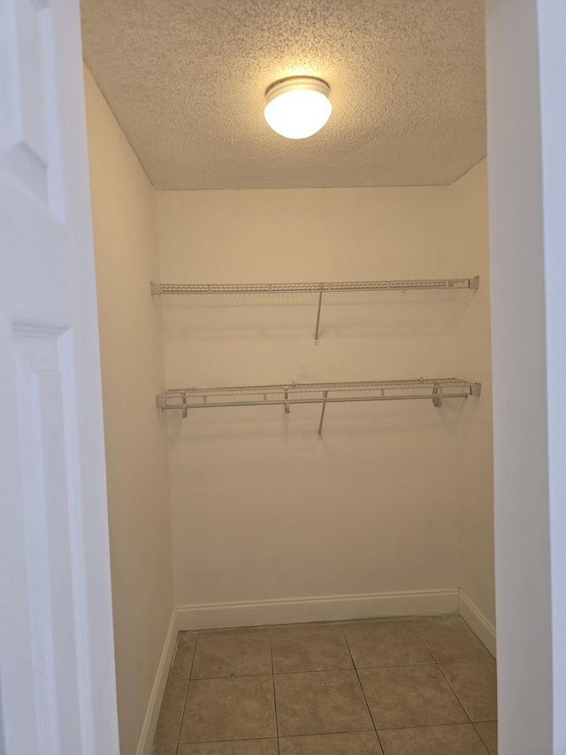 walk in closet with tile patterned floors