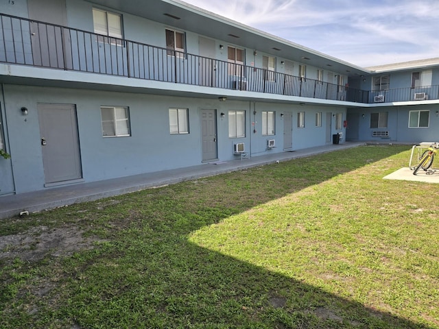 rear view of property with a yard and stucco siding