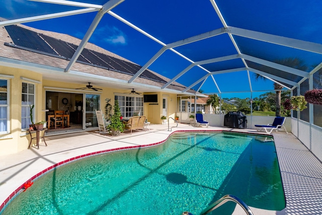 view of swimming pool with a patio area, a fenced in pool, glass enclosure, and a ceiling fan