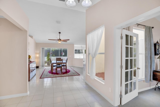 dining room with ceiling fan with notable chandelier, light tile patterned flooring, visible vents, and baseboards