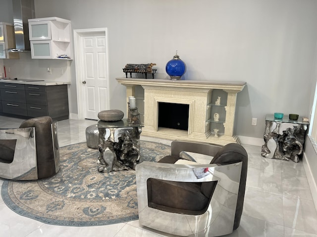 living room with marble finish floor, a fireplace, and baseboards