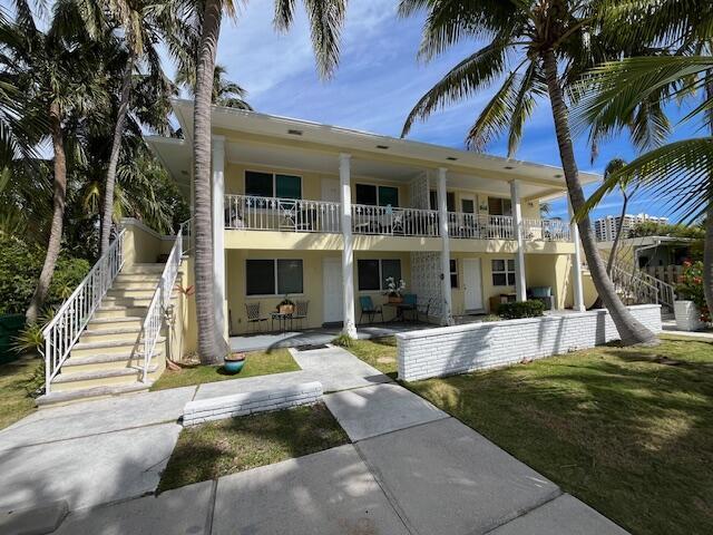 exterior space with stairs and a front lawn