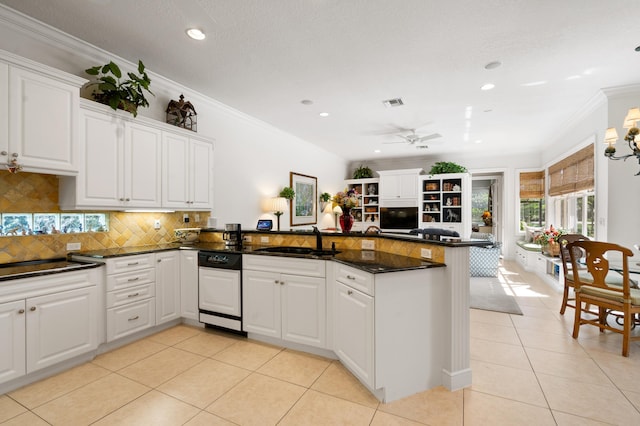 kitchen with ornamental molding, light tile patterned floors, decorative backsplash, a peninsula, and a sink