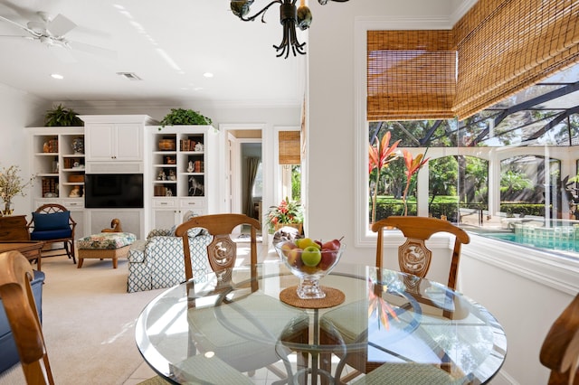 dining area featuring visible vents, a sunroom, ceiling fan, light carpet, and crown molding