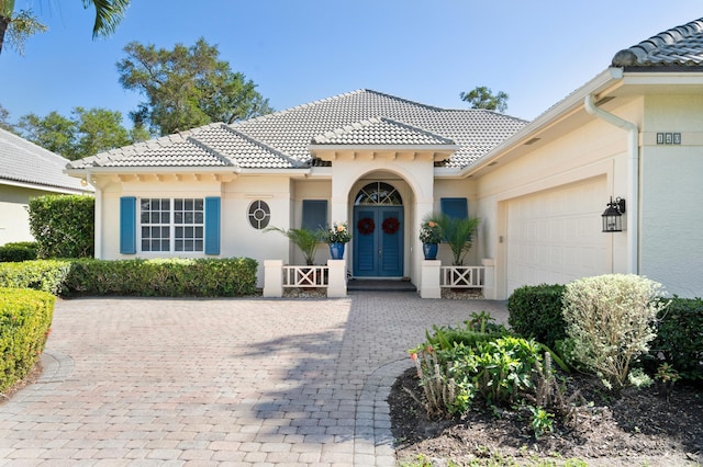 view of front of property featuring french doors, a tile roof, and a garage