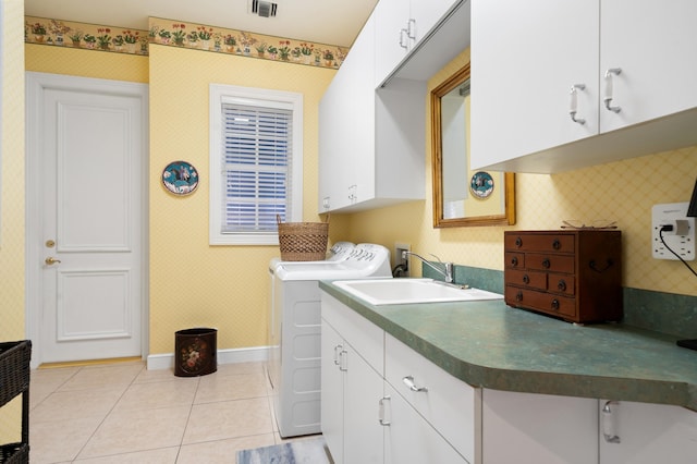 washroom with a sink, cabinet space, wallpapered walls, baseboards, and washing machine and clothes dryer