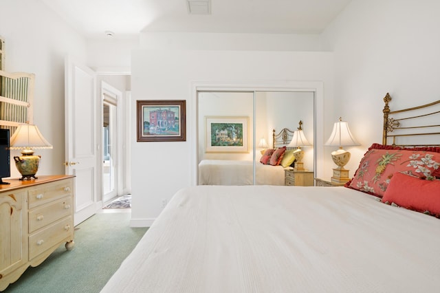 bedroom featuring a closet, visible vents, baseboards, and carpet