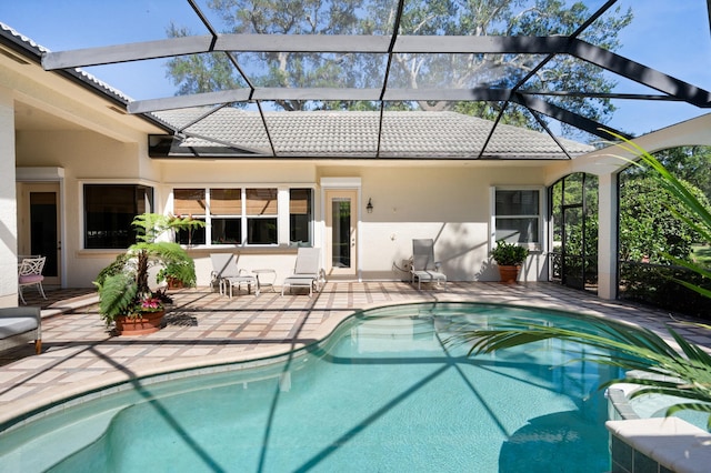 pool with glass enclosure and a patio