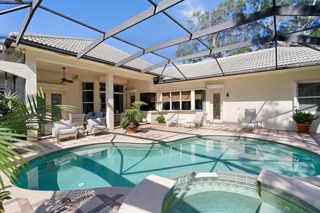 view of swimming pool with glass enclosure, a patio, a pool with connected hot tub, and ceiling fan