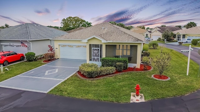 ranch-style home featuring stucco siding, driveway, a yard, roof with shingles, and a garage