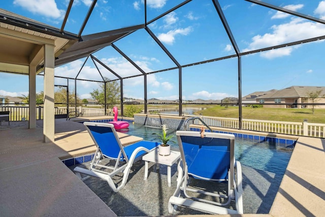 outdoor pool featuring glass enclosure, a water view, and a patio area