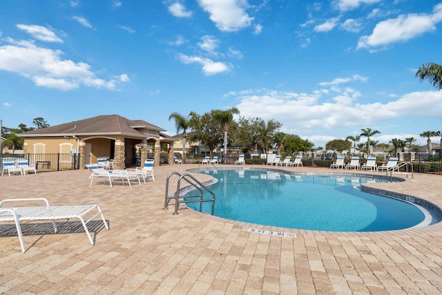 community pool with a patio and fence