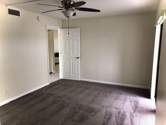 unfurnished bedroom featuring carpet floors, baseboards, visible vents, and ceiling fan