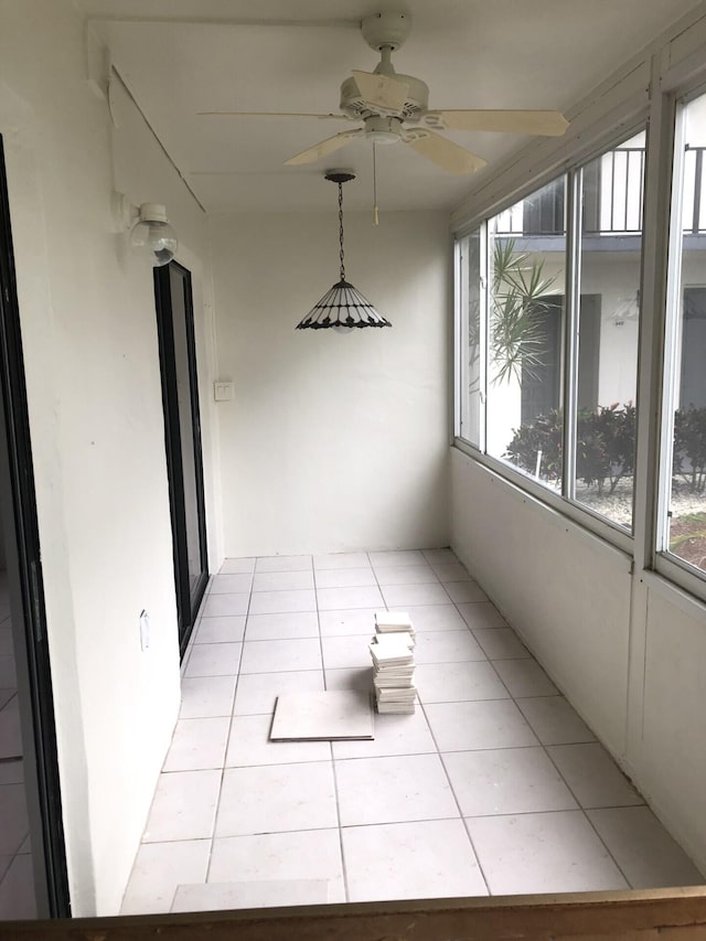 unfurnished sunroom featuring a ceiling fan