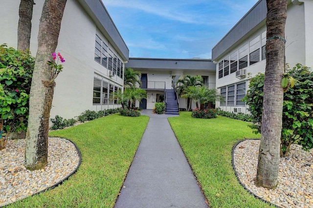 view of property's community featuring stairway and a lawn