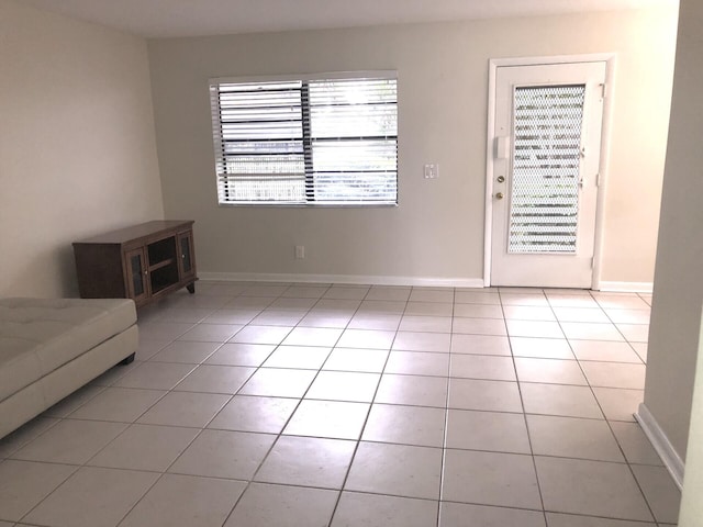 interior space with baseboards and light tile patterned floors