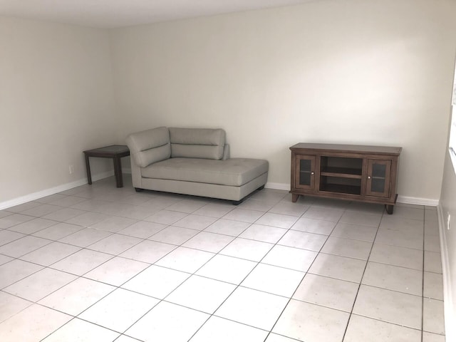 unfurnished room with light tile patterned floors and baseboards