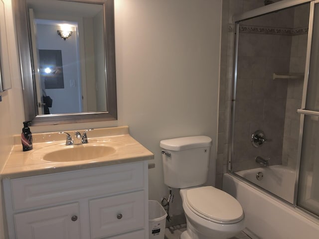 bathroom featuring vanity, toilet, and bath / shower combo with glass door