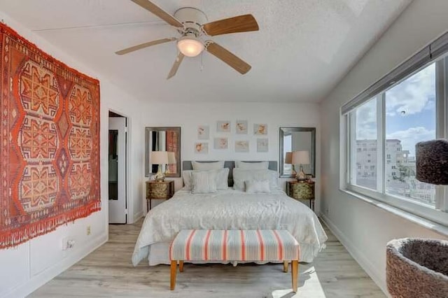 bedroom featuring light wood-style flooring, baseboards, and ceiling fan