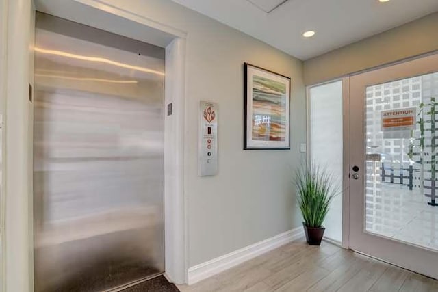 foyer featuring recessed lighting, elevator, wood finished floors, and baseboards