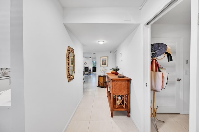 hallway featuring light tile patterned floors and baseboards