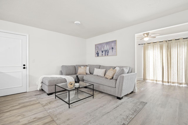 living area with ceiling fan, baseboards, and wood finished floors