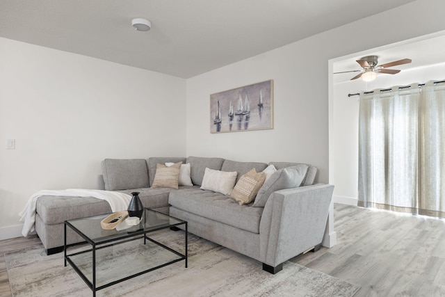 living area with baseboards, plenty of natural light, and light wood-style floors