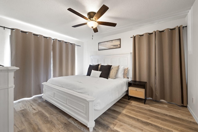 bedroom featuring ceiling fan, a textured ceiling, and wood finished floors