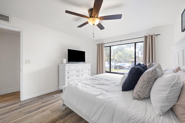 bedroom featuring visible vents, ceiling fan, a textured ceiling, light wood-type flooring, and baseboards