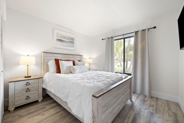 bedroom featuring baseboards and light wood finished floors