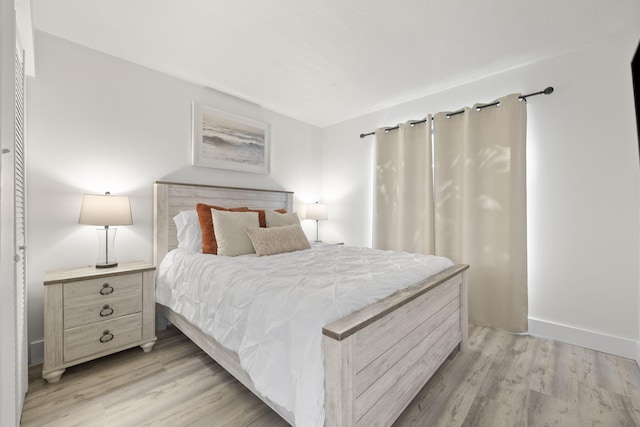 bedroom featuring light wood-type flooring and baseboards