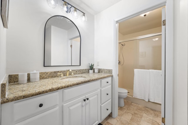 full bathroom featuring a stall shower, vanity, and toilet