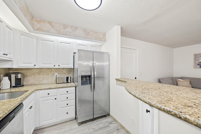 kitchen featuring appliances with stainless steel finishes, white cabinetry, and light wood finished floors